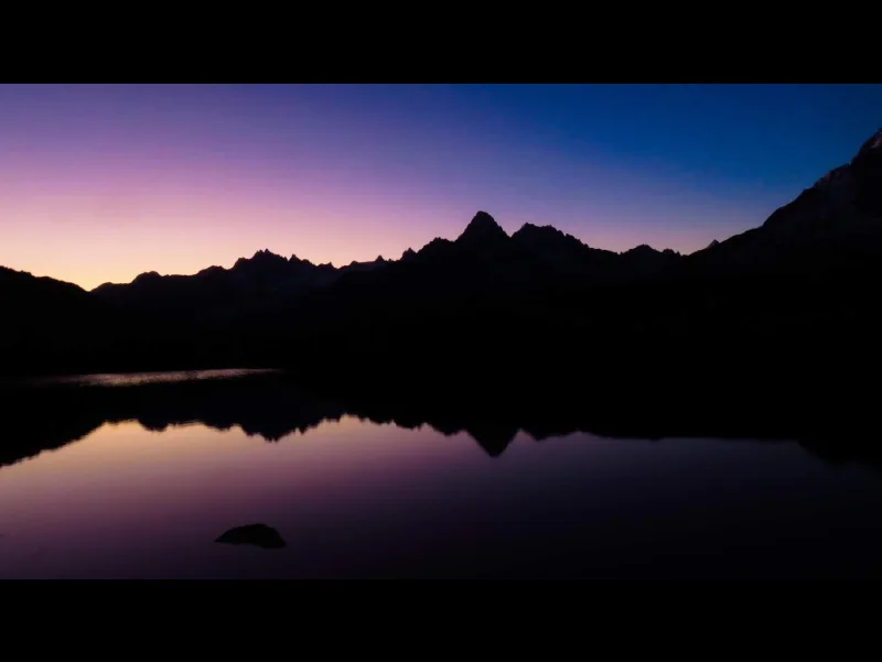 Aurore sur le Lac de Chéserys. Photo de paysage artistique mêlant le violet et le doré d'un lever de soleil.