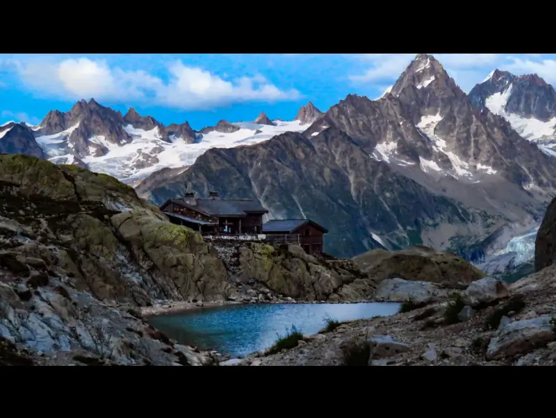 Photo de paysage, le Lac Blanc en premier plan, un chalet refuge et l'Aiguille Verte en arrière-plan.